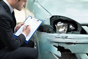 Insurance assessor examining car